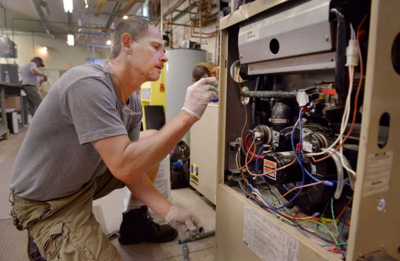 BRUNSWICK, ME - AUGUST 25: The Maine Energy Marketers Association's technical education center, in Brunswick, offers an instructional program for people looking into the heating and air conditioning maintenance business. Steven Sweet, from Windham, works on a gas furnace at the center. (Photo by John Ewing/Portland Portland Press Herald via Getty Images)